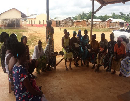 group of women gather in a cirlce for microcredit training