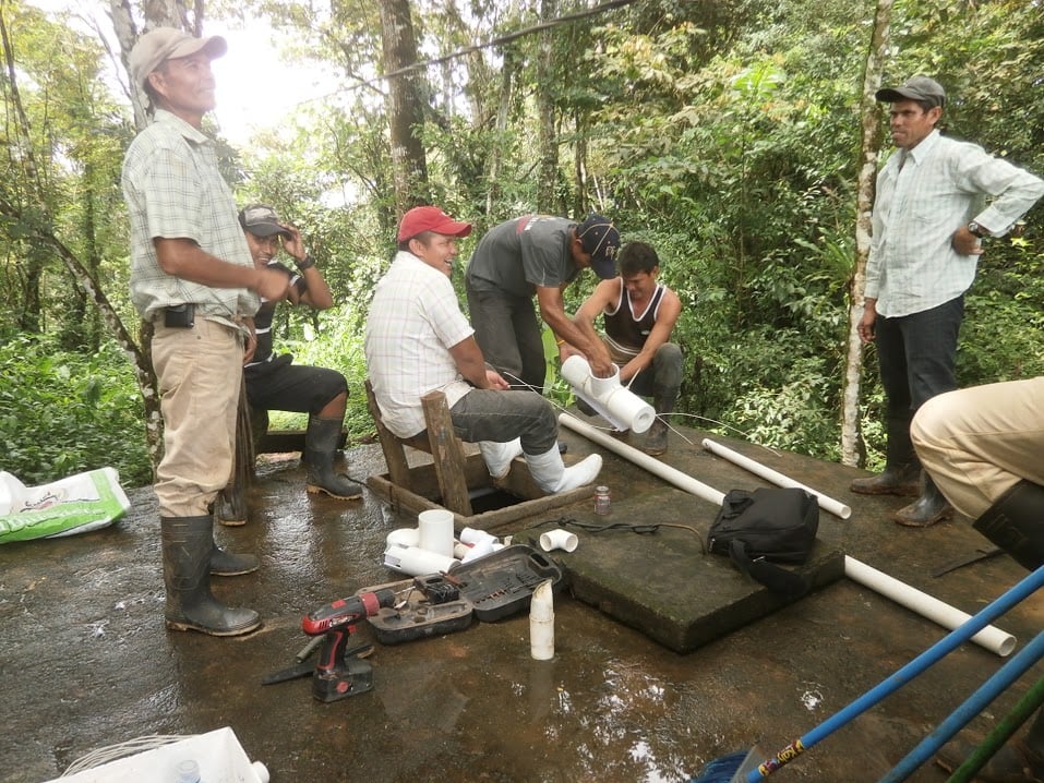 a group of men install a new water chlorination system