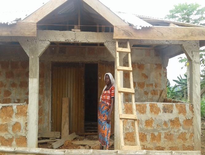 woman stands in front of a ladder and the construction of a building