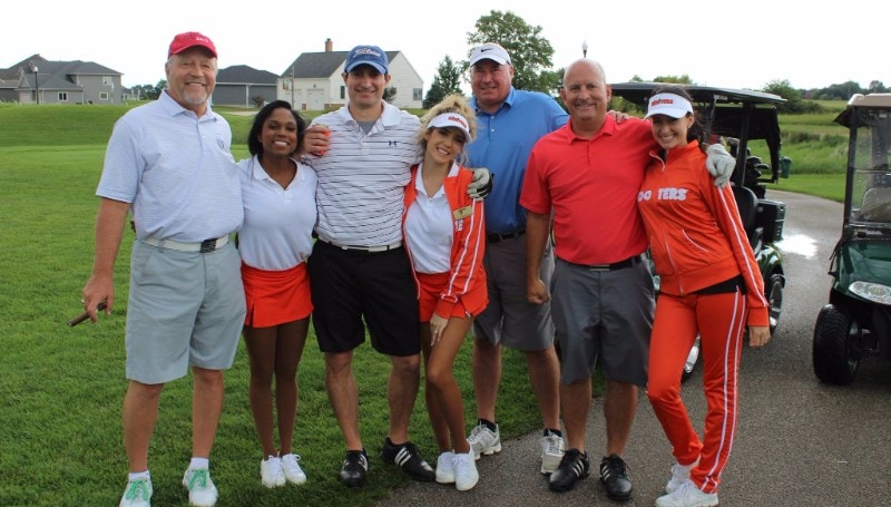 Hooters girls pose with a group of golfers