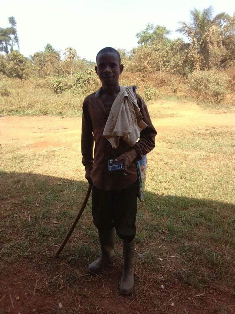 Abdullai man stands posing for picture in the shade