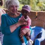 Mary Jane Oakland holds an infant in rural Ghana