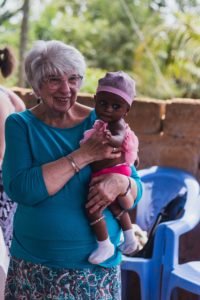 Mary Jane Oakland holds an infant in rural Ghana