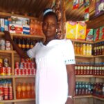 Mary stands inside her store, with shelves stocked and a satisfied look on her face