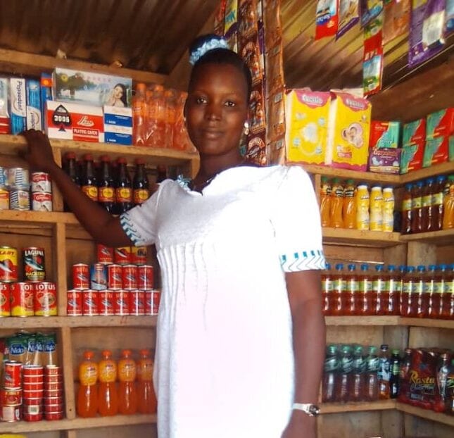 Mary stands inside her store, with shelves stocked and a satisfied look on her face