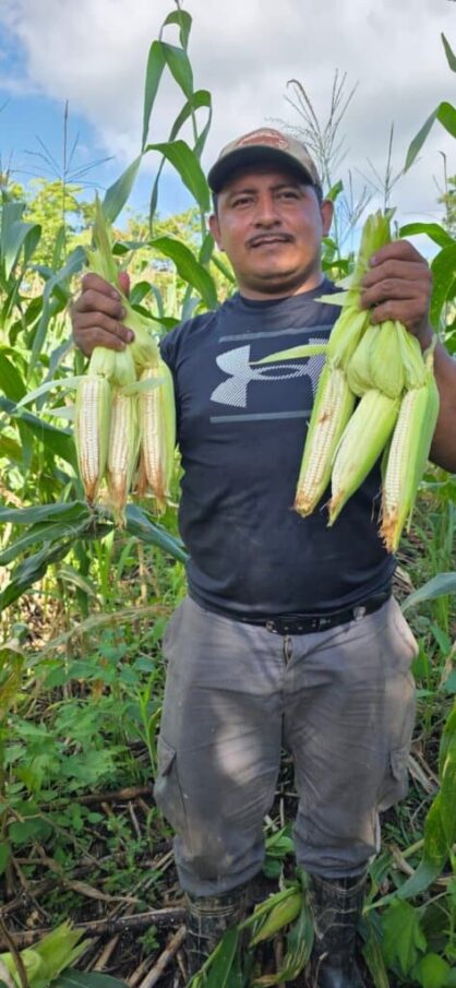 A farmer showing off his corn.