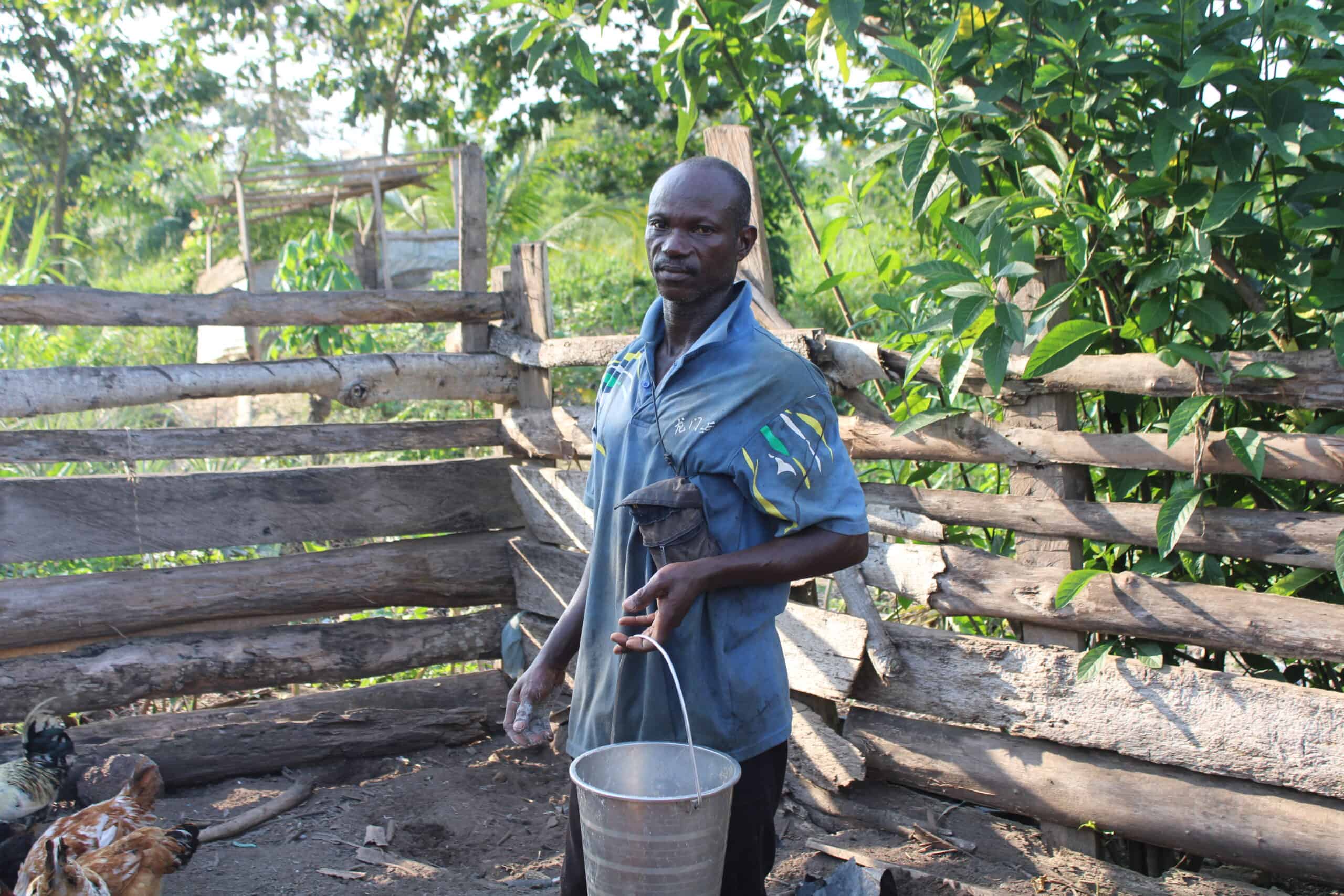 a farmer giving water to his chickens