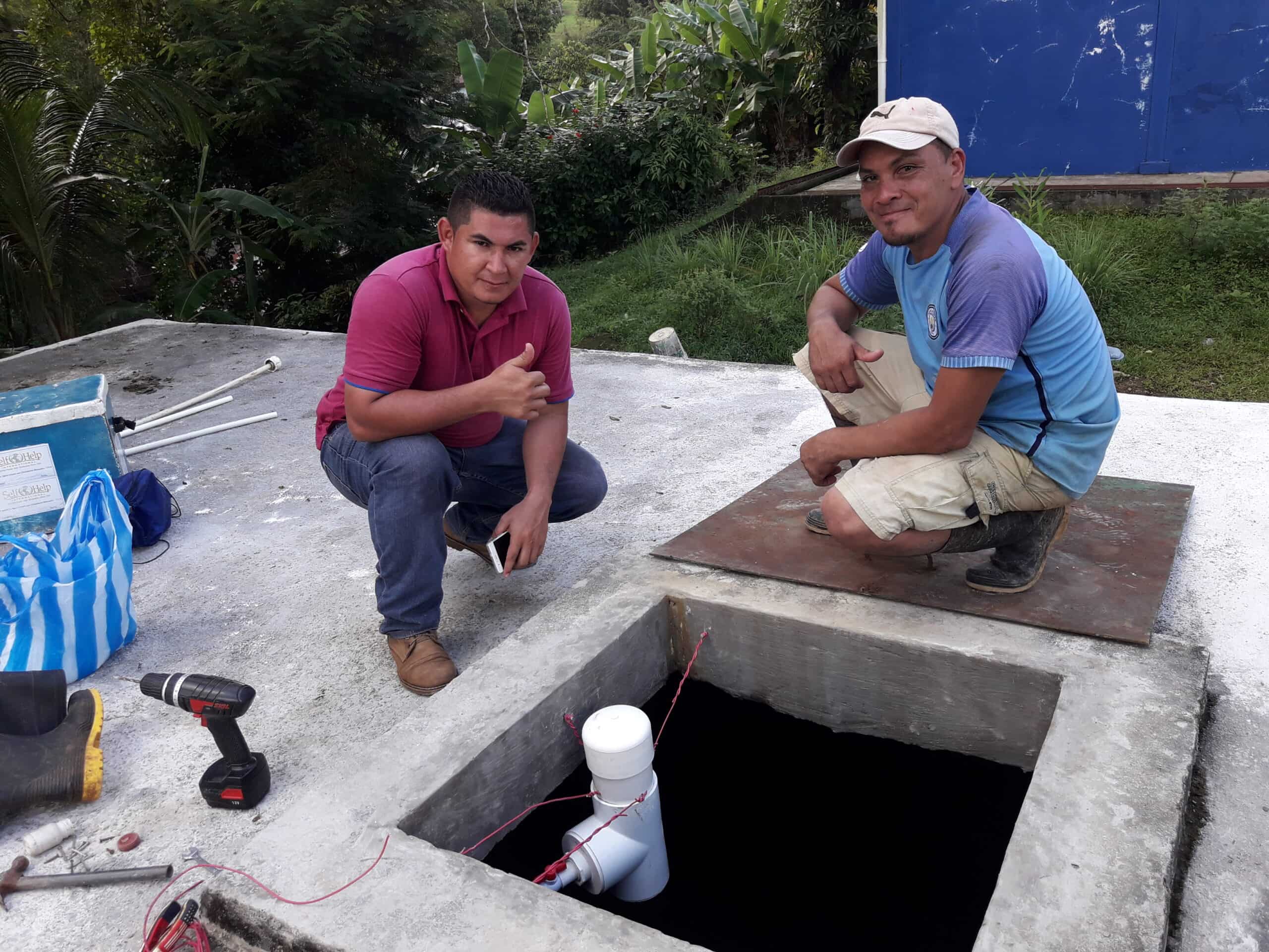 Self-Help International Nicaragua staff on a water tank.
