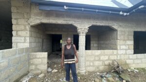 Ruth Thrives With Support from Self-Help International 3 Ruth, a Self-Help International microcredit client, stands in front of her unfinished home.